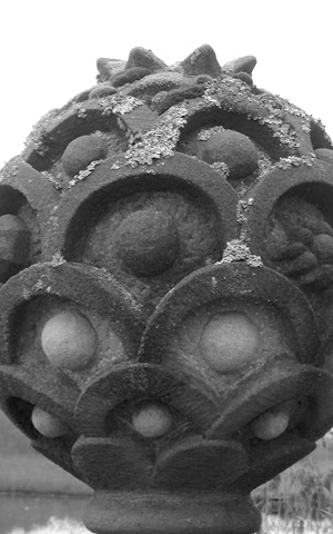 Trauertätigkeit - schwarz-weißes Foto einer Steinkugel mit stilisierten Blättern